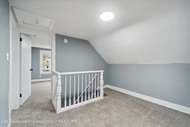 additional living space featuring lofted ceiling and light carpet