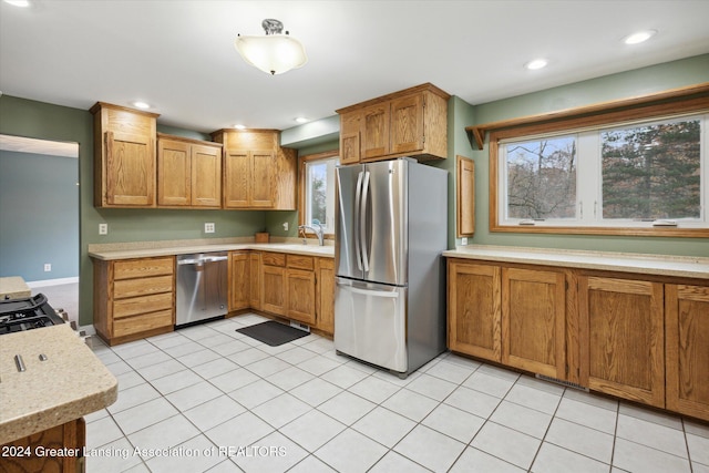 kitchen with stainless steel appliances, light tile patterned floors, and sink