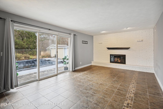 unfurnished living room with tile patterned floors and a brick fireplace