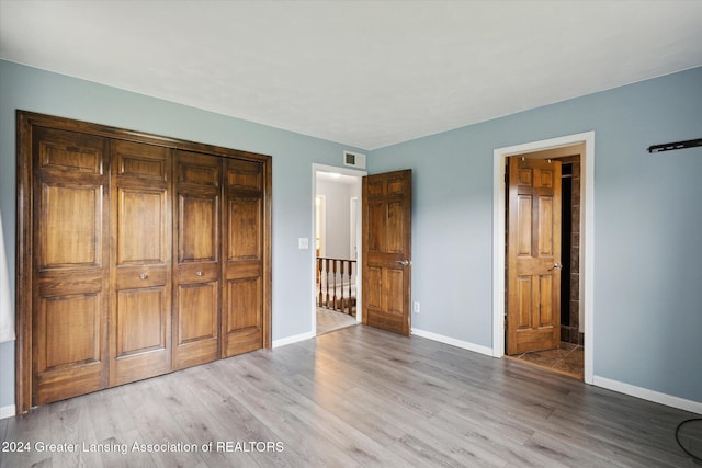 unfurnished bedroom with a closet and light hardwood / wood-style flooring