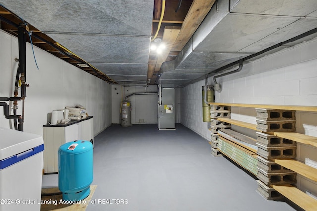 basement featuring water heater and heating unit