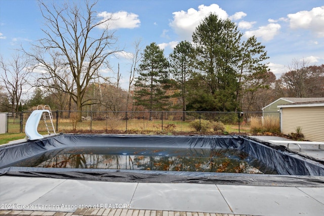 view of pool featuring a diving board and a water slide