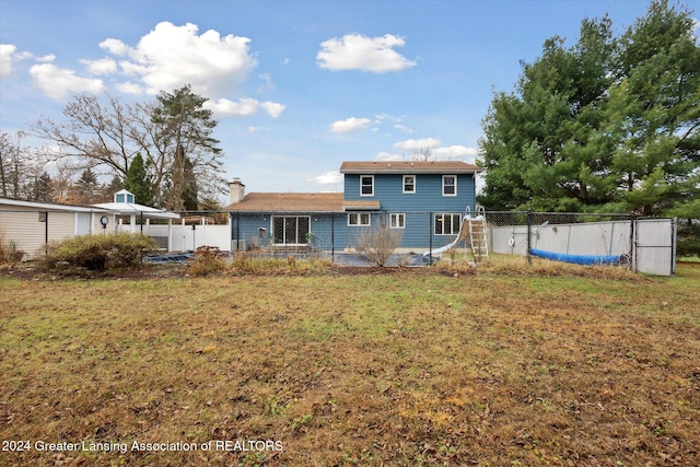 rear view of property with a lawn