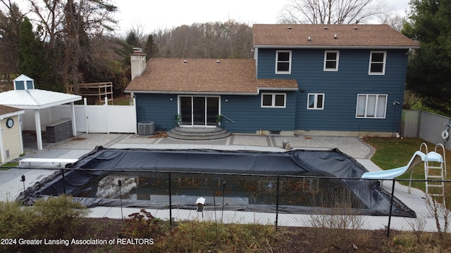 rear view of house with a covered pool and a patio