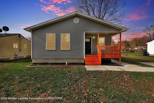 bungalow-style home with a porch and a lawn