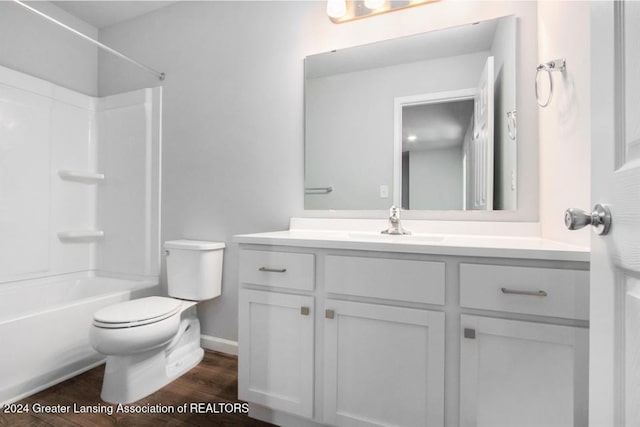 full bathroom featuring wood-type flooring, shower / tub combination, toilet, and vanity