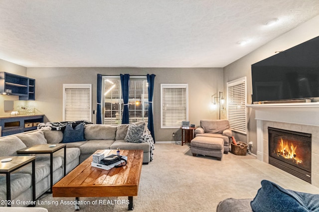 carpeted living room with a textured ceiling and a fireplace