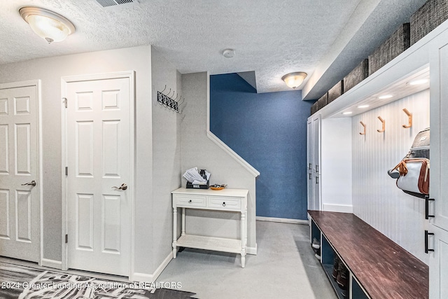 mudroom featuring a textured ceiling