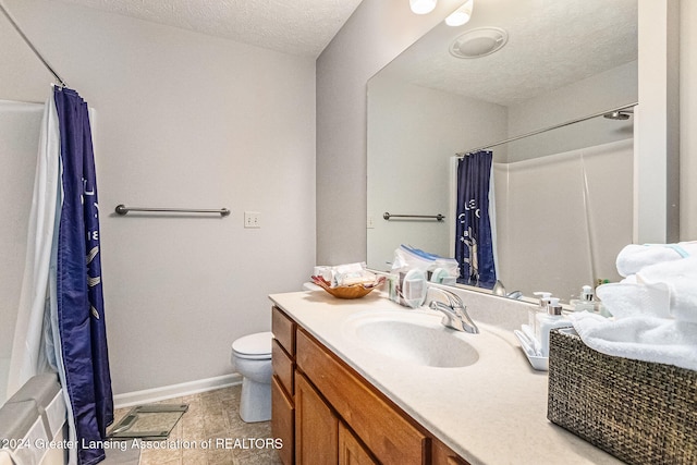 bathroom with toilet, vanity, a textured ceiling, and tile patterned flooring