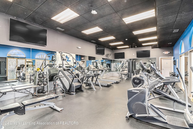 workout area with a drop ceiling and a towering ceiling