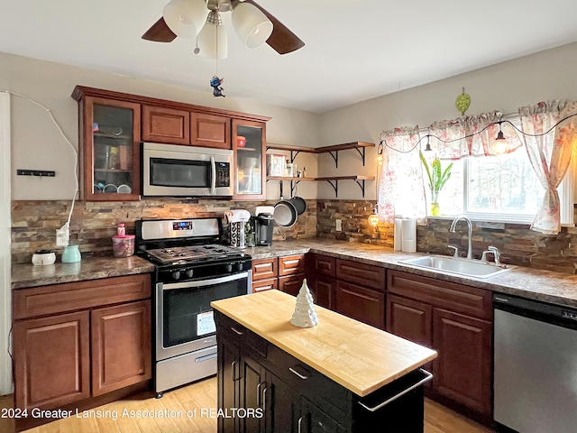 kitchen featuring butcher block countertops, appliances with stainless steel finishes, decorative backsplash, sink, and light hardwood / wood-style floors