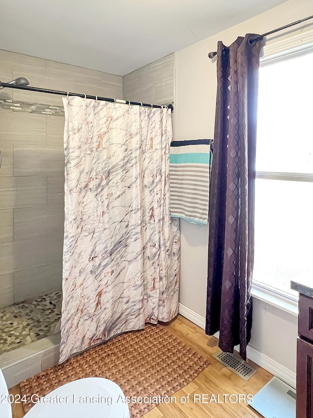 bathroom featuring a shower with shower curtain and hardwood / wood-style flooring