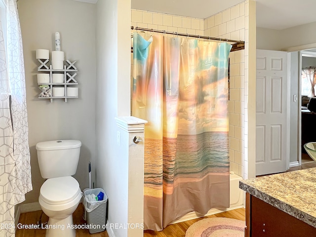 full bathroom featuring wood-type flooring, shower / bath combination with curtain, toilet, and vanity