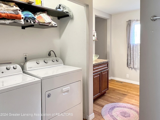 washroom featuring independent washer and dryer and light hardwood / wood-style flooring