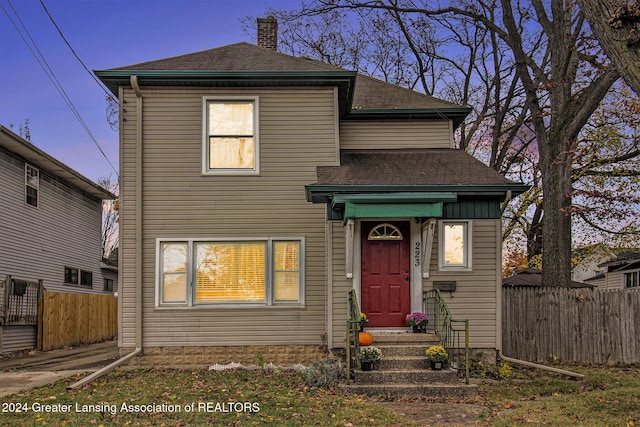 223 S Pennsylvania Ave, Lansing, MI 48912 - view of front facade featuring fence, a chimney, and roof with shingles