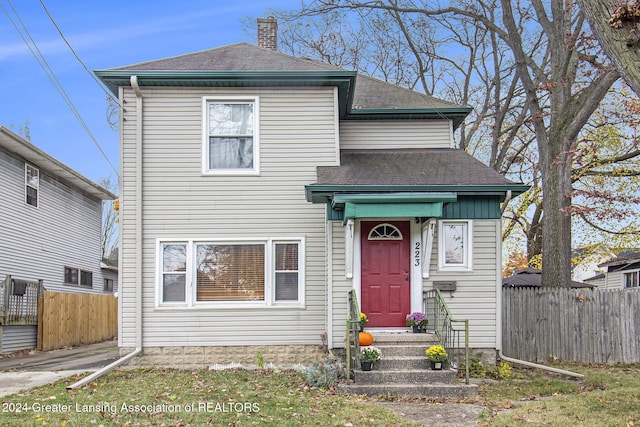 223 S Pennsylvania Ave, Lansing, MI 48912 - view of front of home featuring fence, roof with shingles, and a chimney