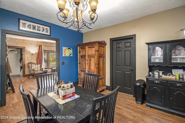 223 S Pennsylvania Ave, Lansing, MI 48912 - dining area featuring a chandelier, light wood-type flooring, and a textured ceiling