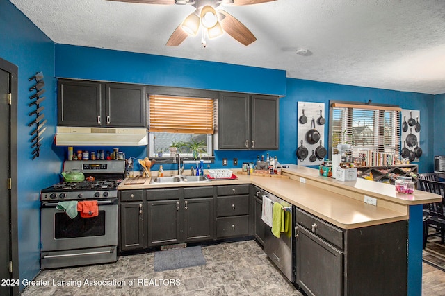 kitchen featuring kitchen peninsula, sink, stainless steel appliances, and a textured ceiling