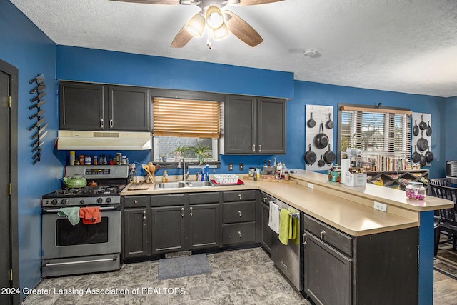 223 S Pennsylvania Ave, Lansing, MI 48912 - kitchen featuring under cabinet range hood, appliances with stainless steel finishes, a sink, a peninsula, and a textured ceiling