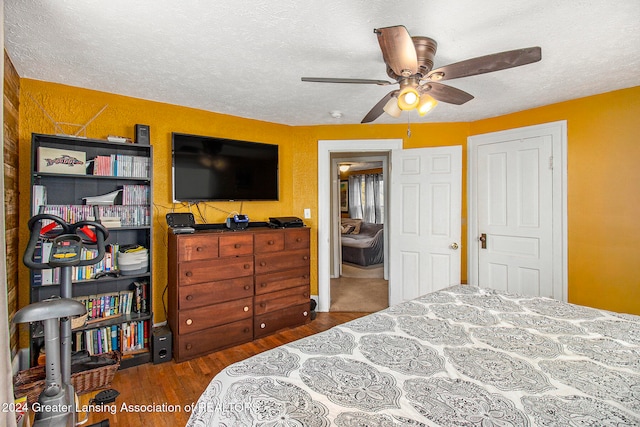 bedroom featuring dark hardwood / wood-style flooring, a textured ceiling, and ceiling fan