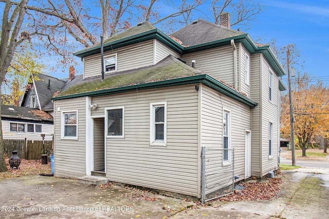 223 S Pennsylvania Ave, Lansing, MI 48912 - rear view of property with a chimney and fence