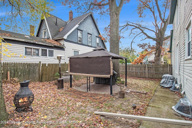223 S Pennsylvania Ave, Lansing, MI 48912 - rear view of property featuring an outdoor fire pit, a gazebo, a chimney, a patio, and a fenced backyard