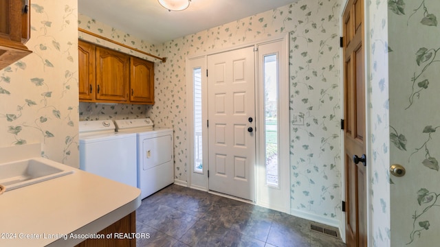 laundry room featuring washing machine and dryer and cabinets