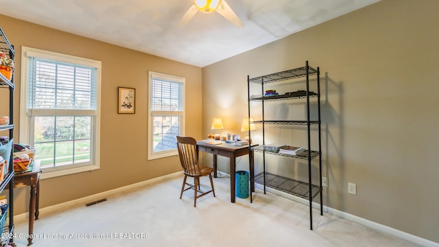 carpeted office space featuring ceiling fan