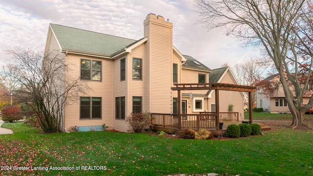 rear view of property with a pergola, a lawn, and a deck