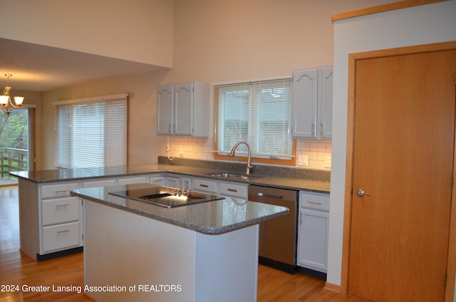 kitchen featuring white cabinets, dishwasher, a kitchen island, and kitchen peninsula