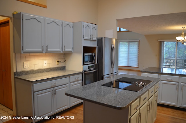 kitchen featuring white cabinets, a center island, light wood-type flooring, and appliances with stainless steel finishes