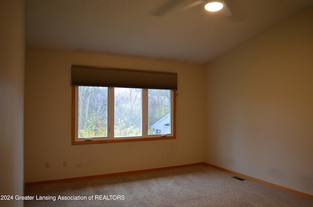 carpeted empty room with vaulted ceiling and ceiling fan