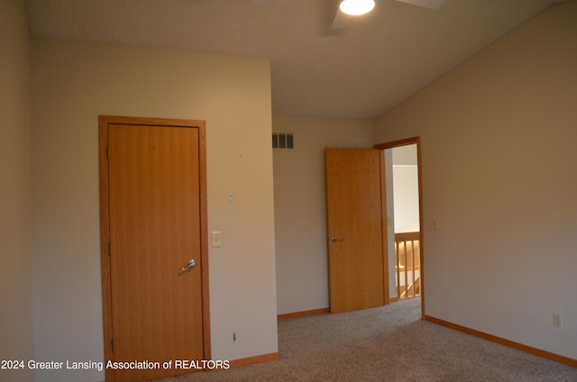 spare room featuring ceiling fan, carpet, and lofted ceiling