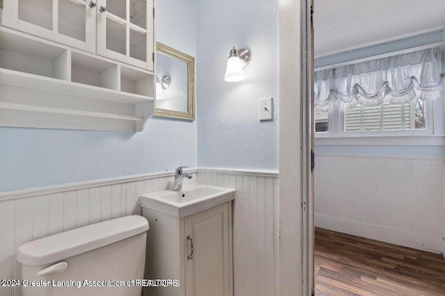 bathroom with hardwood / wood-style floors, vanity, and toilet