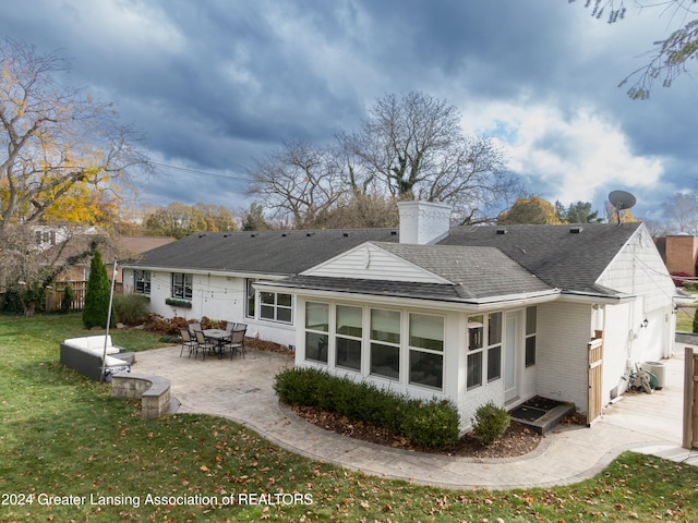 back of house with a patio area and a lawn