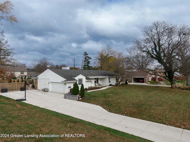 ranch-style home featuring a garage and a front lawn