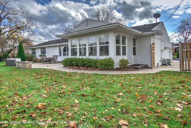 back of house with a patio and a yard