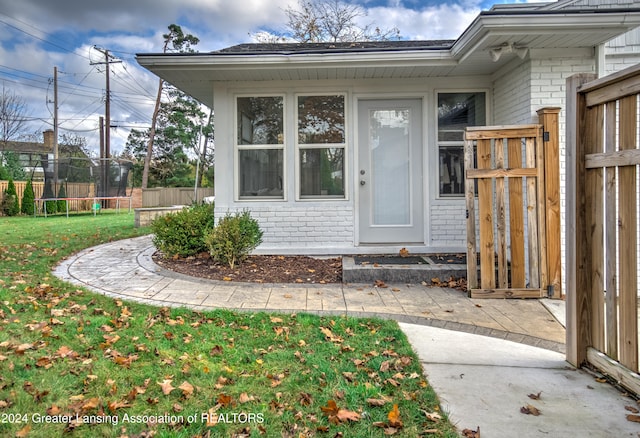 entrance to property with a lawn