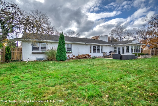 rear view of property with a lawn and a patio