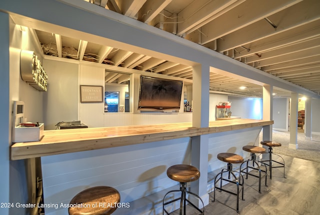 bar featuring butcher block countertops and wood-type flooring