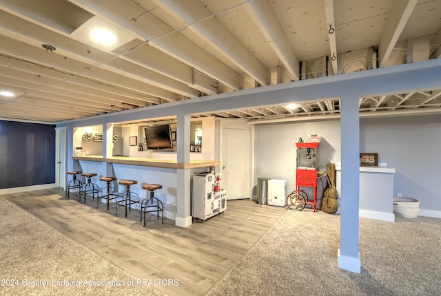 basement with hardwood / wood-style floors and indoor bar