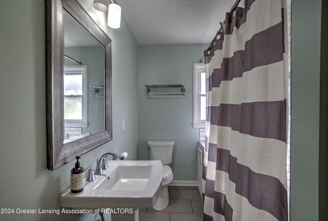 bathroom with toilet, sink, tile patterned flooring, and a shower with shower curtain