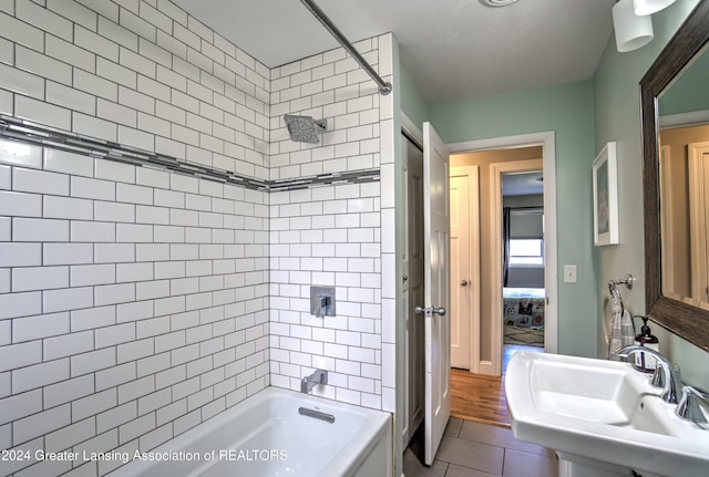 bathroom featuring tiled shower / bath, sink, and tile patterned floors