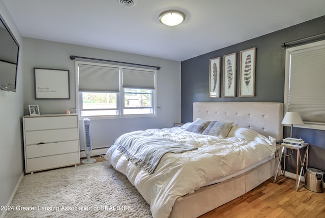 bedroom with baseboard heating and light wood-type flooring