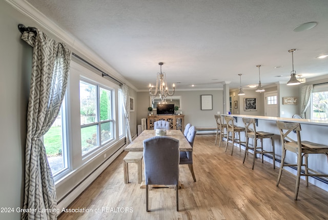 dining space with crown molding, a textured ceiling, an inviting chandelier, light hardwood / wood-style floors, and a baseboard radiator