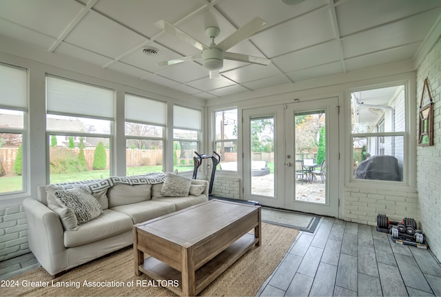 sunroom / solarium featuring french doors, a healthy amount of sunlight, and ceiling fan