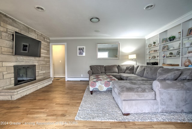 living room featuring crown molding, baseboard heating, light hardwood / wood-style floors, and a fireplace