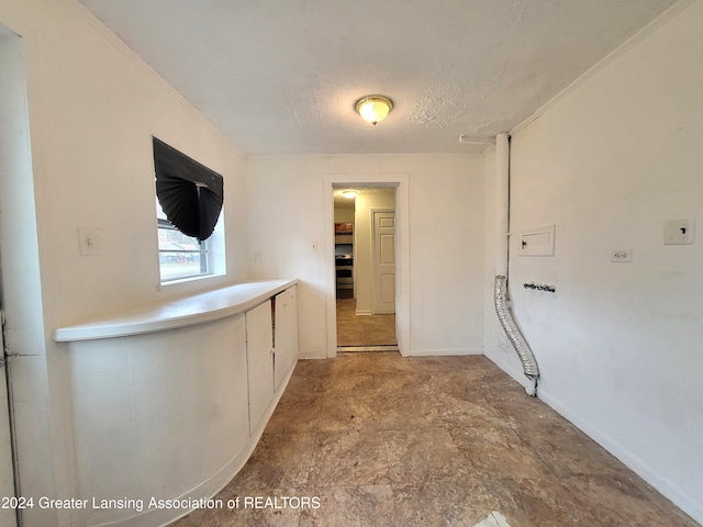 hallway with a textured ceiling and crown molding