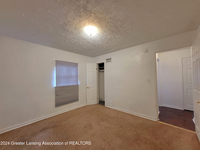 carpeted spare room featuring a textured ceiling