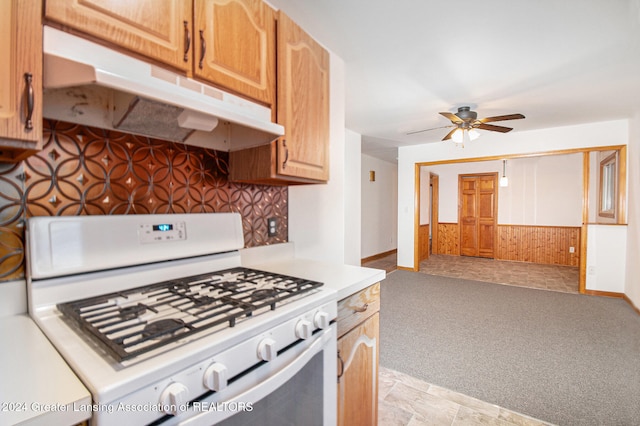 kitchen with gas range gas stove, light carpet, and ceiling fan